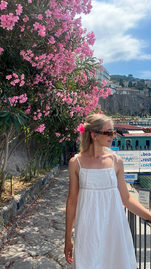 Megan in a white sundress under pink oleander