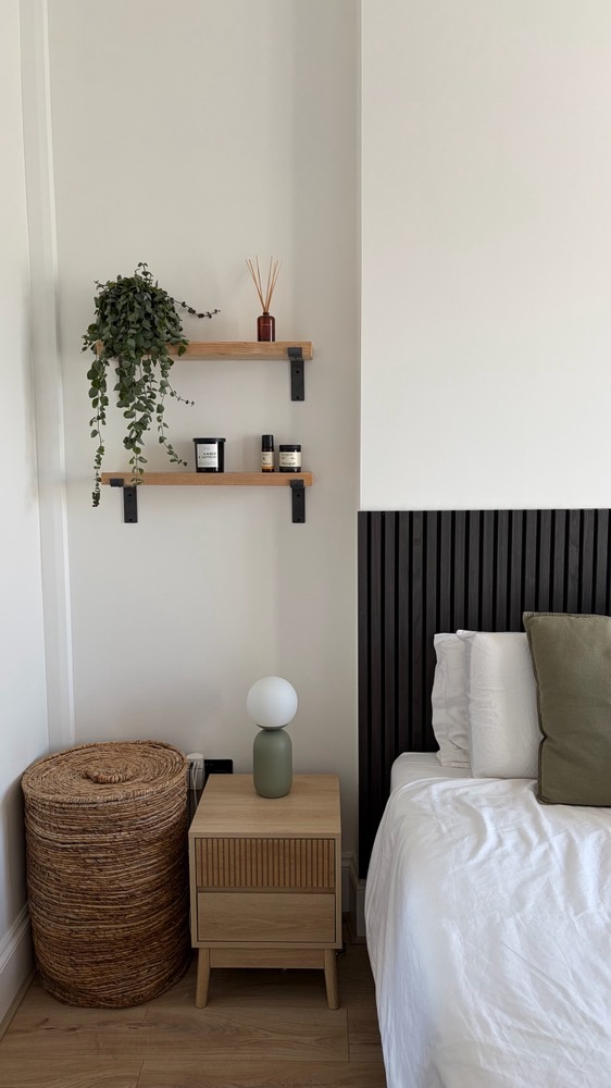 Styled bedroom corner with shelves, plant and rattan basket